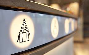 Detailaufnahme einer beleuchteten Wand mit stilisierten Figuren.