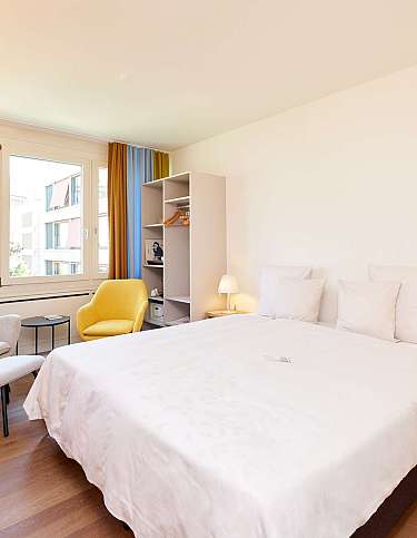 Ein modernes Schlafzimmer mit einem offenen Kleiderschrank und einer Lampe.