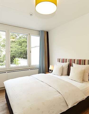 Gemütliches Schlafzimmer mit Doppelbett und Blick ins Grüne.