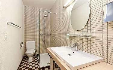 Helles Badezimmer mit Dusche, Waschbecken und WC.