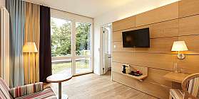 Modernes Hotelzimmer mit Sofa, Tisch und Fernseher.