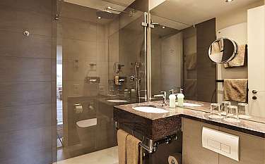 Elegantes Badezimmer mit Glasdusche und Doppelwaschbecken.