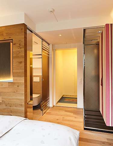 Ein stilvolles Hotelzimmer mit Holzdetails und Dusche.