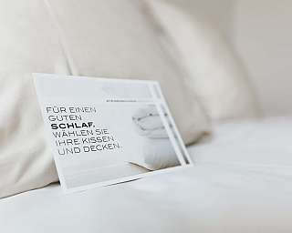 Ein Hinweis auf einem Bett für die Auswahl von Kissen und Decken.