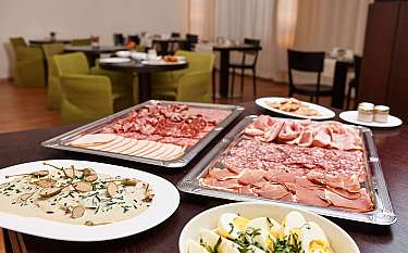 Ein Buffet mit verschiedenen Wurstsorten und einem Gericht mit Eiern.