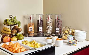 Vielfältige Cerealien und frisches Obst auf einem Frühstückstisch.